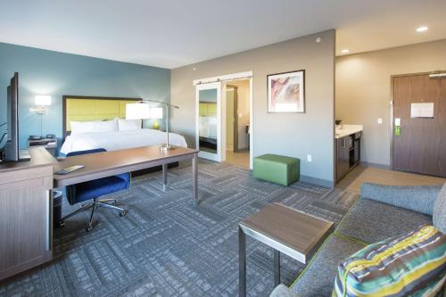 a hotel room with a bed and a desk and a couch at Hampton Inn & Suites Stroud in Stroud