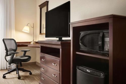 a room with a desk with a microwave and a chair at Hampton Inn & Suites Washington-Dulles International Airport in Sterling