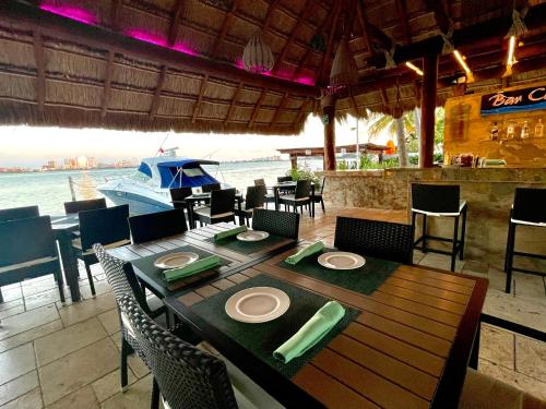a table and chairs in a restaurant with a boat at Sina Suites Cancun in Canc&uacute;n