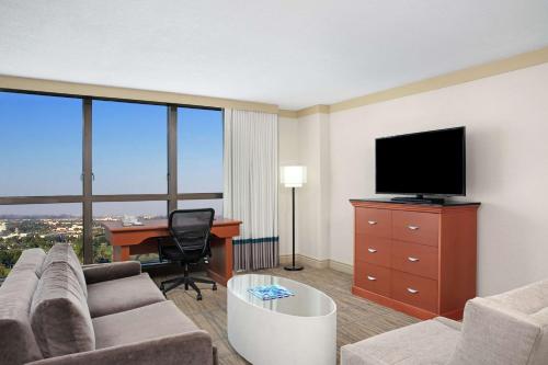 a living room with a couch and a tv and a desk at DoubleTree by Hilton Hotel Miami Airport & Convention Center in Miami