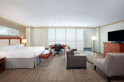 a hotel room with a bed and a desk and a television at DoubleTree by Hilton Hotel Miami Airport & Convention Center in Miami
