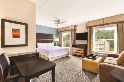 a hotel room with a bed and a desk at Homewood Suites Atlanta Airport North in Atlanta