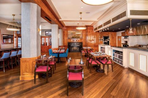 a restaurant with wooden floors and tables and chairs at Hotel Roanoke & Conference Center, Curio Collection by Hilton in Roanoke