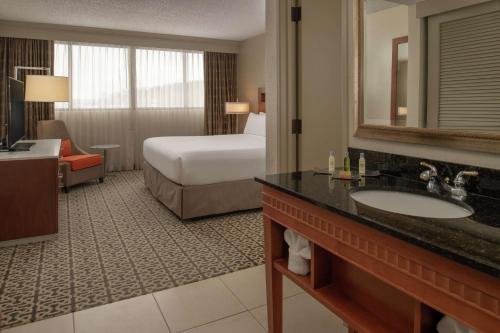 a hotel room with a bed and a bathroom with a sink at DoubleTree Suites by Hilton Seattle Airport/Southcenter in Tukwila