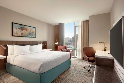 a hotel room with a bed and a desk and a window at Hilton Garden Inn Chicago Downtown South Loop in Chicago