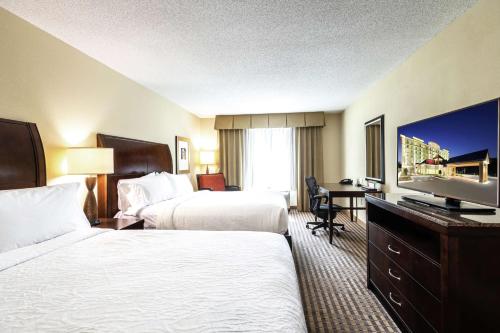 a hotel room with two beds and a flat screen tv at Hilton Garden Inn Atlanta Airport North in Atlanta