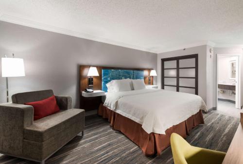 a hotel room with a bed and a chair at Hampton Inn & Suites Chicago-Hoffman Estates in Hoffman Estates
