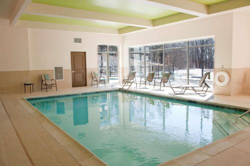 a swimming pool with chairs in a building at Hilton Garden Inn Closest Foxwoods in Preston