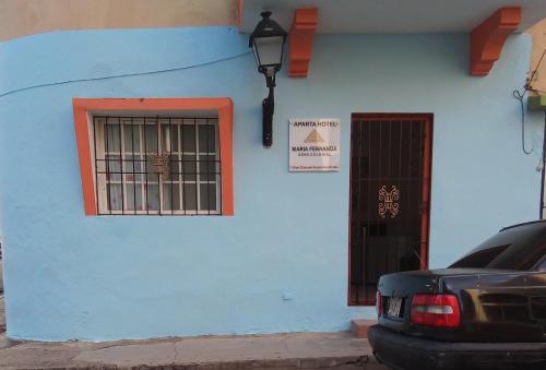 niebieski budynek z oknem i drzwiami w obiekcie Hostal María Fernanda w mieście Santo Domingo
