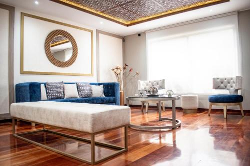 sala de estar con sofá azul y techo dorado en Mountainside Beer Spa & Lodge en Baños