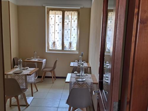 ein Esszimmer mit 2 Tischen und einem Fenster in der Unterkunft B&B Verdi in Lecce