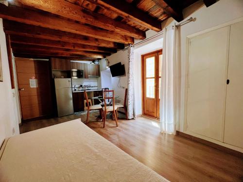 sala de estar con techos de madera y cocina en Felices Los Cuatro, en Toledo