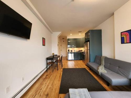 a living room with a couch and a table at Deluxe Studio minutes from NYC! in Union City