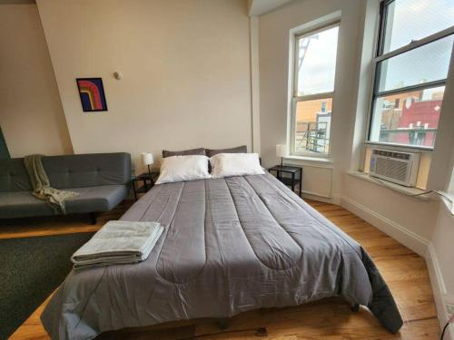 ein Schlafzimmer mit einem großen Bett und einem Sofa in der Unterkunft Deluxe Studio minutes from NYC! in Union City