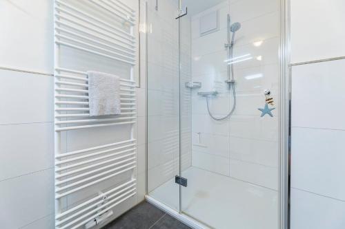 La salle de bains est pourvue d'une douche avec une porte en verre. dans l'établissement Meeresblick-Grosse-Freiheit-Haus-1-WE-9, à Hohwacht