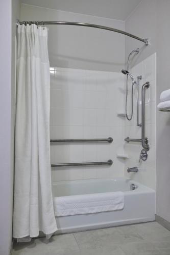 a bathroom with a shower with a white shower curtain at Fairfield Inn & Suites Burlington in Burlington