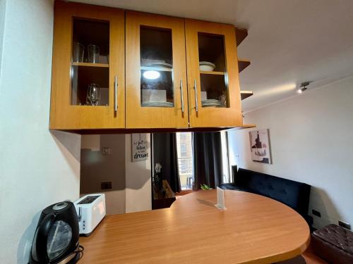a kitchen with a wooden table and cabinets at Apartamentos City Centro Los Leones in Santiago