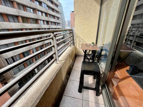 a balcony with a table and a bench on a building at Apartamentos City Centro Los Leones in Santiago