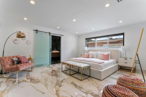 een slaapkamer met een bed, een bank en een stoel bij Villa Bianco in Miami