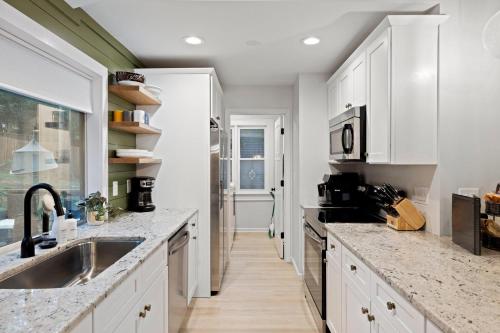 a kitchen with white cabinets and marble counter tops at Near Biltmore, Hiking, Breweries W Game Room in Fletcher