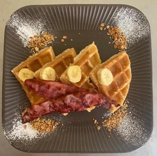 a plate with waffles and bacon and waffles with bananas at Real Hispano in Valladolid