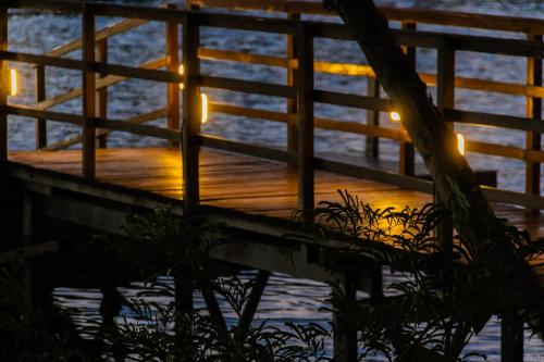 a wooden walkway with lights on the water at Ap do Maro in Barreirinhas