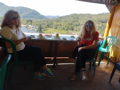 two women sitting in chairs in a room with a table at FARILA LODGE in Kelimutu