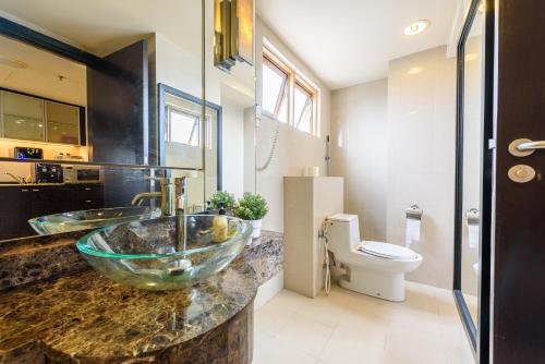La salle de bains est pourvue d'un lavabo en verre et de toilettes. dans l'établissement Resort Homestay 2-6pax 1min to Sunway Pyramid, à Petaling Jaya