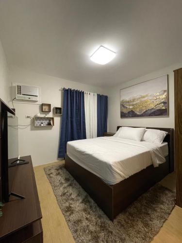 a bedroom with a large bed and a television at FLY & REST GUESTHOUSE - Mactan-Cebu International Airport in Lapu Lapu City