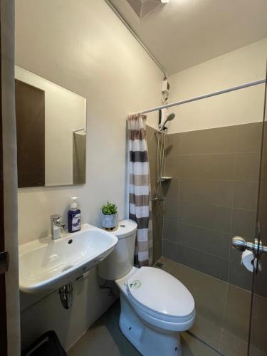 a bathroom with a toilet and a sink and a shower at FLY & REST GUESTHOUSE - Mactan-Cebu International Airport in Lapu Lapu City