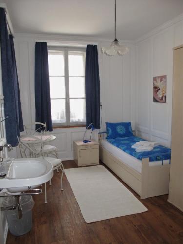 ein Schlafzimmer mit einem Bett und einem Waschbecken sowie ein Badezimmer in der Unterkunft Garni Bar Post in Castasegna