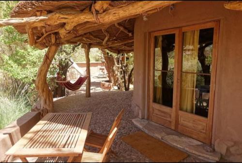a patio with a bench and a glass door at Off the Grid Lakauta Lodge in San Pedro de Atacama