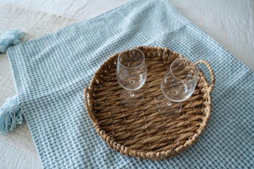 a basket with two wine glasses on a table at OCEAN VIEW DELUXE SUITE: PVT. BEACH & POOL in San Juan