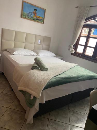 1 dormitorio con 1 cama con manta y ventana en Casa de Itapocoróy Entre o parque Beto Carrero e o mar!, en Penha