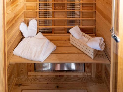 a wooden cabinet with towels and shoes in it at Cosy apartment with sauna in the Black Forest in Sulz am Neckar