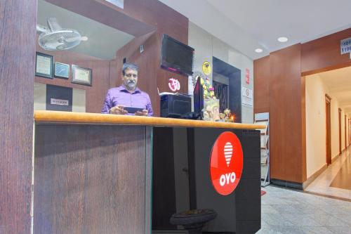 a man standing at a counter in a hospital lobby at Collection O 9796 Hotel Alekhya Residency in Hyderabad