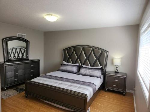 a bedroom with a large bed and a mirror at Beautiful home away from home in Milton