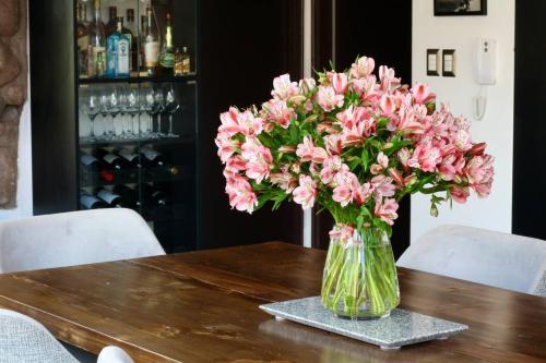 a vase of pink flowers sitting on a table at Casa de ensueño en el Valle Sagrado in Calca