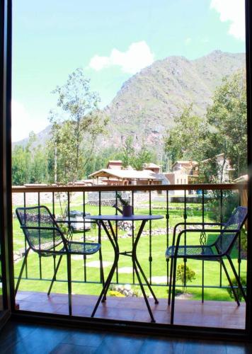 a patio with two chairs and a table on a balcony at Casa de ensueño en el Valle Sagrado in Calca