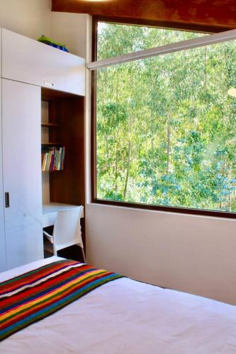 a bedroom with a bed and a large window at Casa de ensueño en el Valle Sagrado in Calca