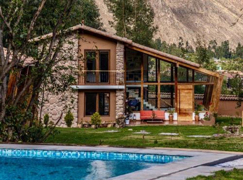 una casa con piscina frente a ella en Casa de ensueño en el Valle Sagrado, en Calca