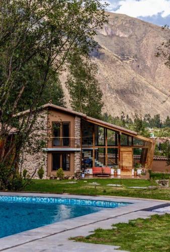 a house with a swimming pool in front of a mountain at Casa de ensueño en el Valle Sagrado in Calca