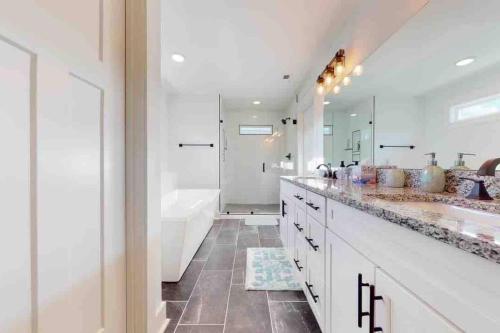 un bagno bianco con 2 lavandini, vasca e doccia di Luxurious LakeHouse NewBuild TimsFord 4BR4BTH a Winchester