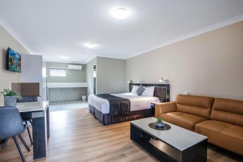 ブリスベンにあるComfort Inn North Brisbaneのベッドとソファ付きのホテルルーム
