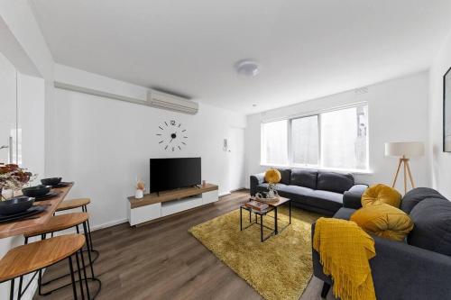 a living room with a blue couch and a tv at Serene Coastal Haven in Melbourne