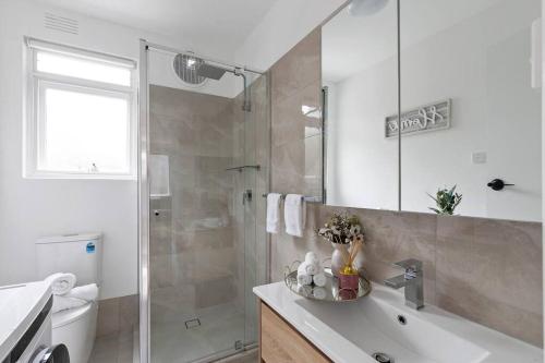 a bathroom with a shower and a sink and a tub at Serene Coastal Haven in Melbourne