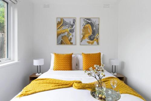 a bedroom with a bed with a yellow blanket at Serene Coastal Haven in Melbourne