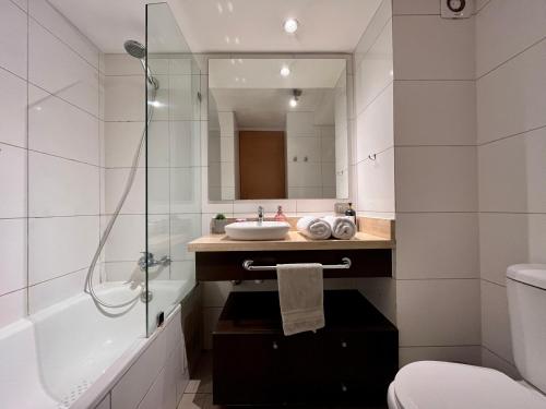 a bathroom with a sink and a toilet and a shower at Apartamentos City Centro Los Leones in Santiago