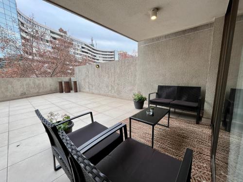 a patio with a table and chairs on a balcony at Apartamentos City Centro Los Leones in Santiago