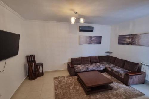 a living room with a couch and a tv at F5 -5 bedrooms Apt- Residence Hasnaoui avec parking Oran Algeria in Oran